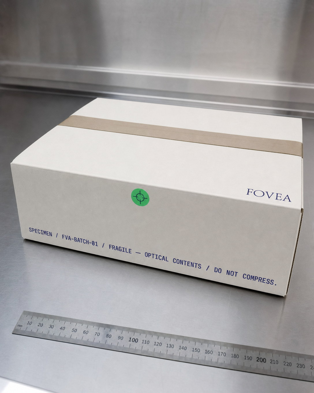 A FOVEA specimen shipping box on a metal surface with measuring ruler and optical handling labels.